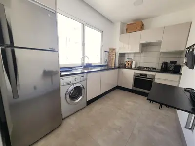 a kitchen with a refrigerator and a washer and dryer at The 41 Maarif by IB Signature - Boho Chic 1BR Apt - with Wifi - Self check-in - 24 x7 Security - City View with terrace - Walk to Cafes! City Centre in Casablanca