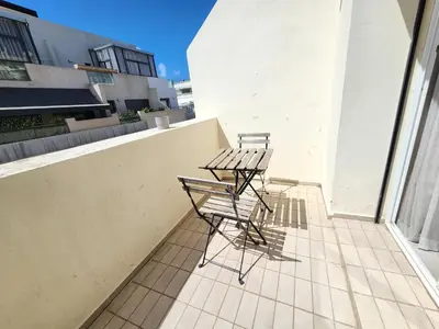 two chairs and tables on the balcony of a building at The 41 Maarif by IB Signature - Boho Chic 1BR Apt - with Wifi - Self check-in - 24 x7 Security - City View with terrace - Walk to Cafes! City Centre in Casablanca