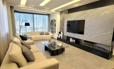 a living room with a couch and a tv at Bel Appartement Spacieux et Lumineux Maarif in Casablanca
