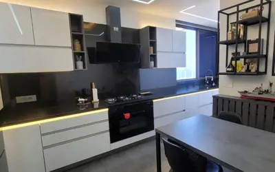 a kitchen with white cabinets and a black stove at Bel Appartement Spacieux et Lumineux Maarif in Casablanca