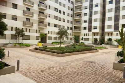 a courtyard in front of a building at Appartement Moderne Équipé Proche Aéroport Mohammed V in Nouaseur