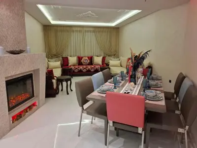 a living room with a table and a fireplace at Prestigious apartment Elegant and refined in Casablanca