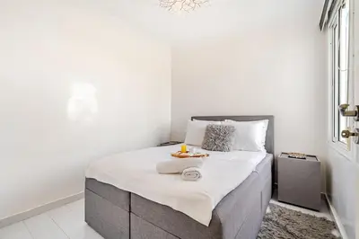 a white bedroom with a large bed with white sheets at Comfort Pool Apartment Heart of Tamaris in Tamaris