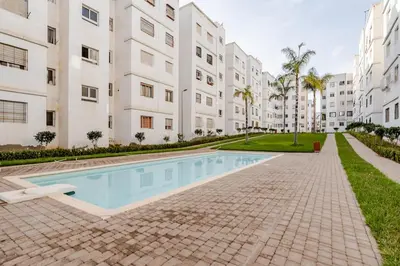 a swimming pool in front of a building at Comfort Pool Apartment Heart of Tamaris in Tamaris