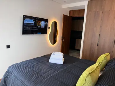 a bedroom with a bed with a tv on the wall at Studio Le Cœur Casablanca in Casablanca
