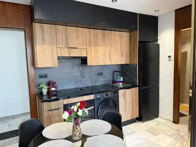a kitchen with a table and a black refrigerator at Studio Le Cœur Casablanca in Casablanca