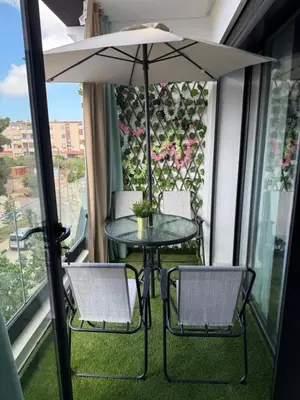 a table and two chairs and an umbrella on a balcony at Studio Le Cœur Casablanca in Casablanca
