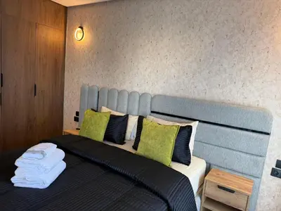 a bedroom with a bed with green and black pillows at Studio Le Cœur Casablanca in Casablanca