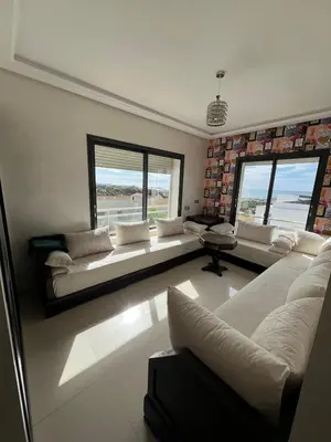 a living room with white couches and a large window at Beachside Charming Apartment in Tamaris