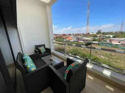 a balcony with two chairs and a large window at Beachside Charming Apartment in Tamaris