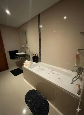a bathroom with a tub with red petals on the floor at Beachside Charming Apartment in Tamaris