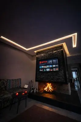 a living room with a fireplace with a tv above it at Luxury Stay in Prestigia Golf City in Bouskoura