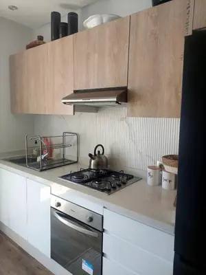 a kitchen with a stove and a tea kettle on it at Appartement neuf avec piscine, balcon et à deux pas de la mer