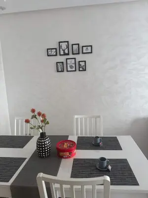 a dining room table with two chairs and a black and white table at Appartement neuf avec piscine, balcon et à deux pas de la mer