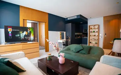 a living room with a green couch and a flat screen tv at Cedar Stays Studio apartment 1chambre salon - WiFi - climatisation - parking - machine a laver- 5 min CFC in Casablanca