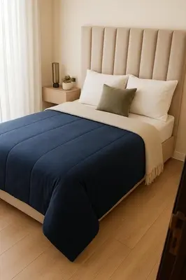 a bedroom with a large bed with a blue blanket at Margueri House in Mohammedia