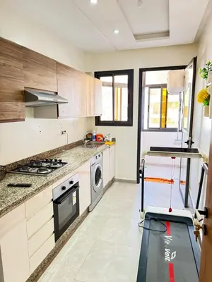 a kitchen with white cabinets and a washer and dryer at Appartement de luxe in Casablanca