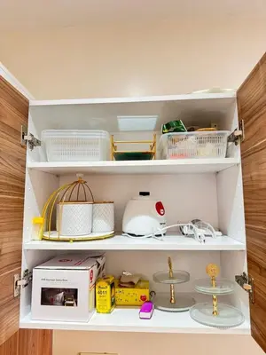 a kitchen pantry with white shelves with food items at Appartement de luxe in Casablanca
