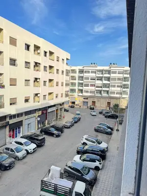 a parking lot with cars parked in front of buildings at Appartement de luxe in Casablanca