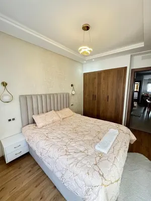 a bedroom with a large bed with a white comforter at Appartement de luxe in Casablanca