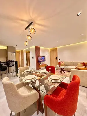 a living room with a glass table and red chairs at Modern studio in Casablanca in Casablanca