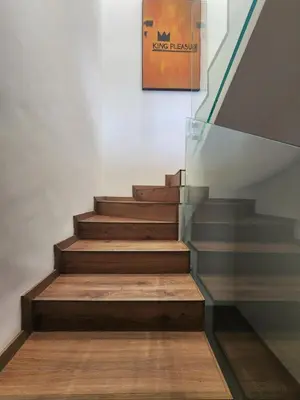 a staircase with wooden floors and a painting on the wall at The 28 Triangle d'Or by IB Signature - Stylish two-Bedroom flat - Wifi, Self Check-in, Day and Night Security, Terrace, Swimming pool, free parking close to all amenities in Casablanca