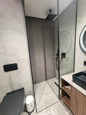 a bathroom with a shower and a toilet and a sink at The 28 Triangle d'Or by IB Signature - Stylish two-Bedroom flat - Wifi, Self Check-in, Day and Night Security, Terrace, Swimming pool, free parking close to all amenities in Casablanca