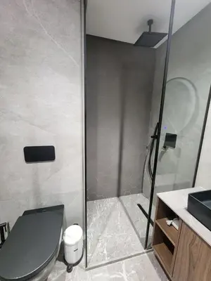 a bathroom with a shower with a toilet and a sink at The 28 Triangle d'Or by IB Signature - Stylish two-Bedroom flat - Wifi, Self Check-in, Day and Night Security, Terrace, Swimming pool, free parking close to all amenities in Casablanca