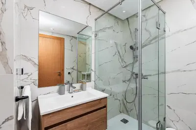 a bathroom with a sink and a glass shower at Luxury Apartment Perles d'Agdal, Facing Agdal Station in Rabat