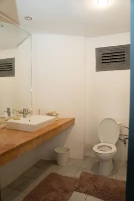 a white bathroom with a sink and a toilet at Spacious and colorful apartment close to MahajRiad in Rabat