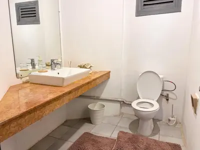 a white bathroom with a sink and a toilet at Spacious and colorful apartment close to MahajRiad in Rabat