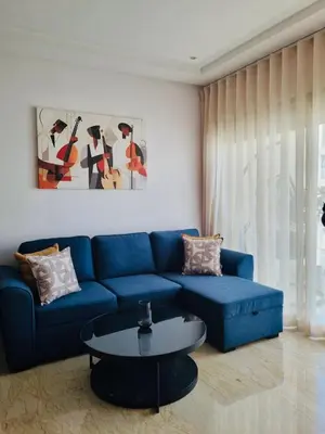 a living room with a blue couch and a table at BenHost Appartement Casablanca Maarif in Casablanca