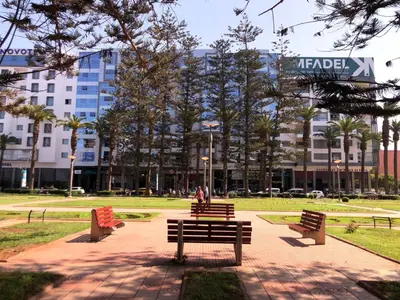 a park with benches in front of a building at Apartment with large terrace Mohammedia in Mohammedia