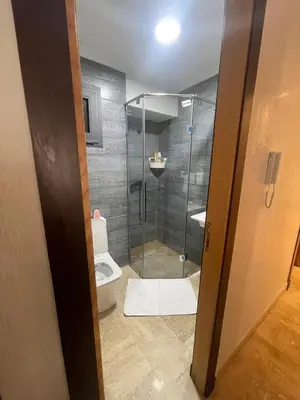 a bathroom with a toilet and a glass shower at Luxury Beach Front Cherrat Plage Apartment in Sidi el Haj Bou Derbala