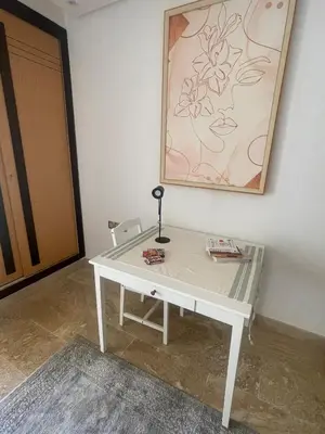 a white desk with a lamp on a wall at Luxury Beach Front Cherrat Plage Apartment in Sidi el Haj Bou Derbala