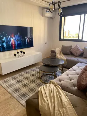 a living room with a large flat screen tv at Luxury Beach Front Cherrat Plage Apartment in Sidi el Haj Bou Derbala