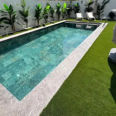 a swimming pool in a yard with grass at Apartement avec piscine privée Casablanca in Casablanca