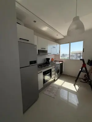 a kitchen with a refrigerator and a stove top oven at Cozy Dream Land Appartement 1 bed room Sea View, Sidi Rahal Beach in Sidi Rahal