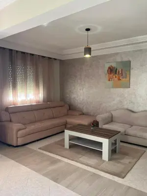 a living room with a couch and a coffee table at Appartement calme et lumineux à Harhoura in El Harhoura