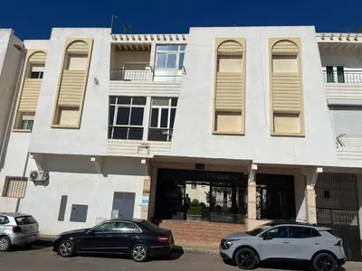 two cars parked in front of a building at Appartement calme et lumineux à Harhoura in El Harhoura