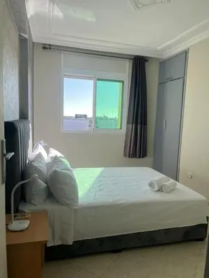 a bedroom with a bed with a window and a desk at Appartement calme et lumineux à Harhoura in El Harhoura