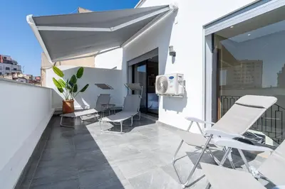 a balcony with chairs and an umbrella on a building at Résidence Dunkerque - Duplex in Casablanca