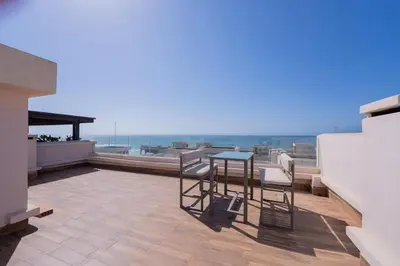 a patio with a table and chairs on a balcony at Villa vue océan Jack Beach Bay in Tamaris