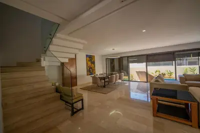 a living room with stairs and a table and chairs at Villa vue océan Jack Beach Bay in Tamaris