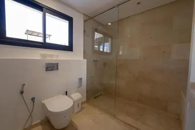a bathroom with a toilet and a glass shower at Villa vue océan Jack Beach Bay in Tamaris