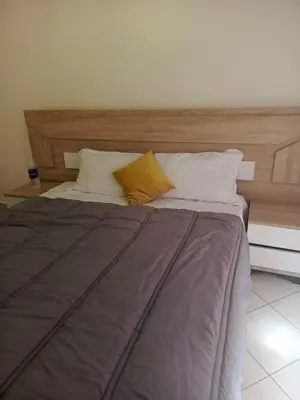 a bed with a wooden headboard and two pillows at Appartement casablanca in Casablanca