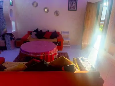 a living room with a red couch and a table at appartement à al tilal in Mohammedia