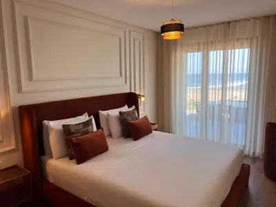 a bedroom with a white bed with pillows and a window at Blue Carrousel in Rabat