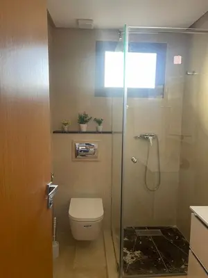 a bathroom with a glass shower with a toilet at Apartment in Manesman beach in Mohammedia