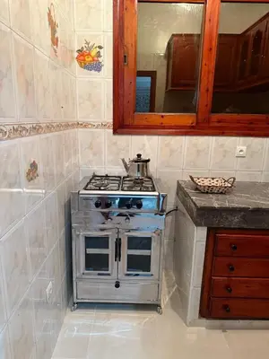 a stove in a kitchen with a counter and a mirror at Beautiful apartment with all comforts in Rabat